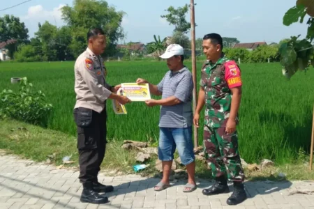 Petugas saat melakukan sosialisasi dan imbauan agar warga Kecamatan Sawahan tidak menggunakan jebakan tikus beraliran listrik di sawah. (foto: Dok Humas Polri)