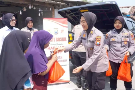 AKP Nawang dan anggota Polwan lainnya membagikan sembako kepada warga Dusun Tanggulrejo Desa Kebonagung Kec. Porong.