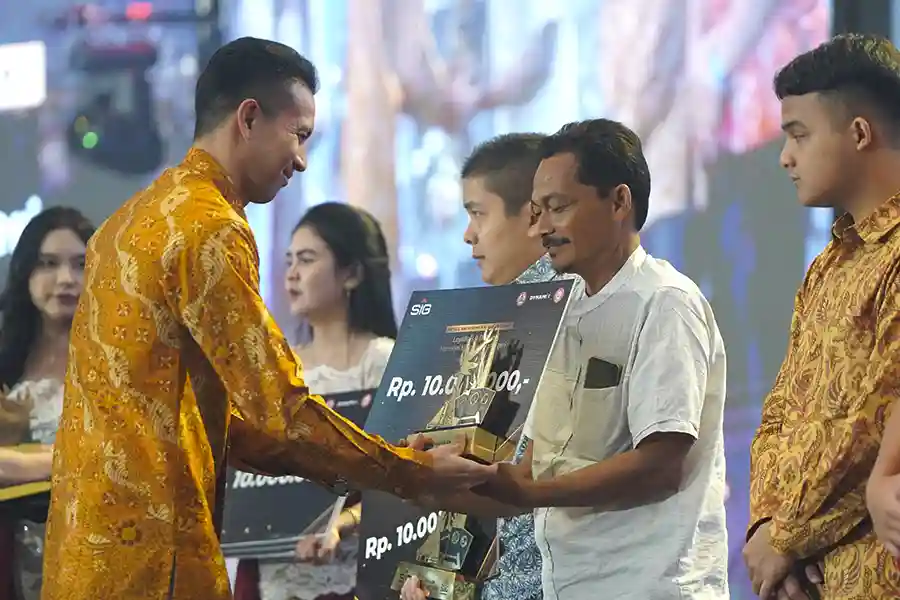 Direktur Pengembangan Bisnis dan Strategy SIG, Dennis Pratistha menyerahkan trofi penghargaan kategori Toko Best Loyalty kepada pemilik Toko Bangunan Dua Ribu, Kabupaten Malang