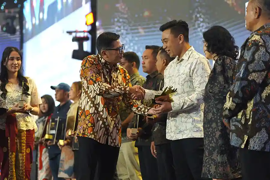 Direktur Sales dan Marketing SIG, Dicky Saelan menyerahkan trofi penghargaan kategori Toko Best Legend kepada pemilik Toko Bangunan Makmur, Kabupaten Kediri